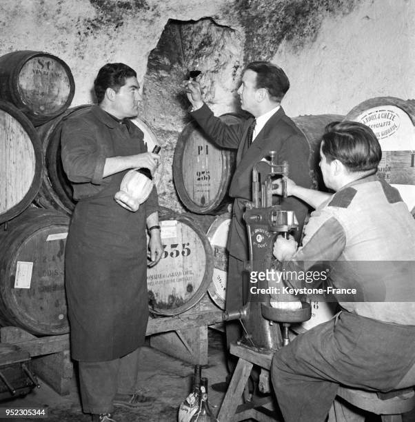 Sommeliers goûtant le vin dans une cave d'un restaurant à Paris, France en 1955.