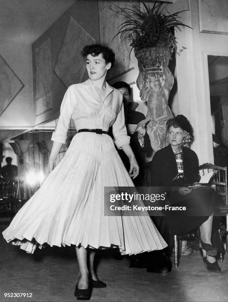 Mannequin présentant un modèle Marcel Rochas : la robe 'Paris Ondée 16' en toile jaune plissée, à Paris en France, le 12 mai 1948.