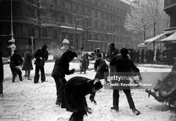 Enfants se lançant des boules de neige dans les rues de Paris, France en mars 1946.