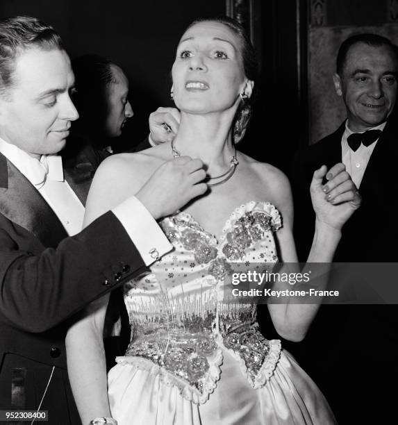 Un grand bijoutier parisien pose un collier au cou d'un mannequin à l'occasion de la soirée organisée par le syndicat des horlogers, bijoutiers,...