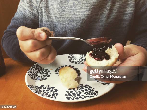 little boy spreading jam on a biscuit - paradise jam stock pictures, royalty-free photos & images