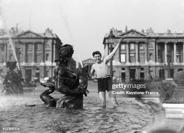 Un homme en maillot de bain se baigne dans la fontaine de la place de la Concorde, à Paris, France en juin 1935.