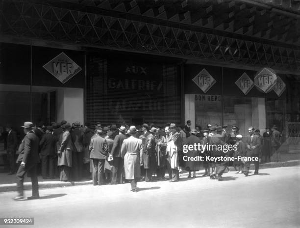 Les passants, devant le grand magasin fermé Aux Galeries Lafayette, lisant une pancarte exposant les revendications des vendeurs et employés...