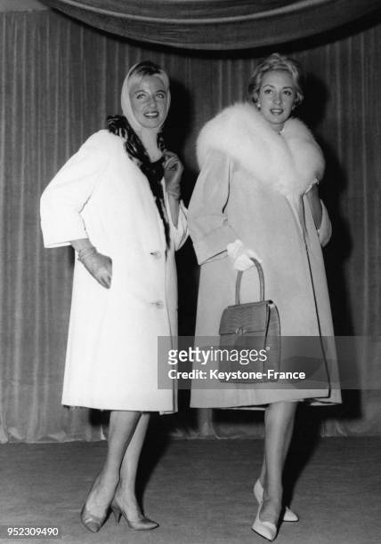 Modèles présentés au salon du cuir à la porte de Versailles à Paris, France, le 6 septembre 1958: un manteau en agneau blanc et un manteau en veau...