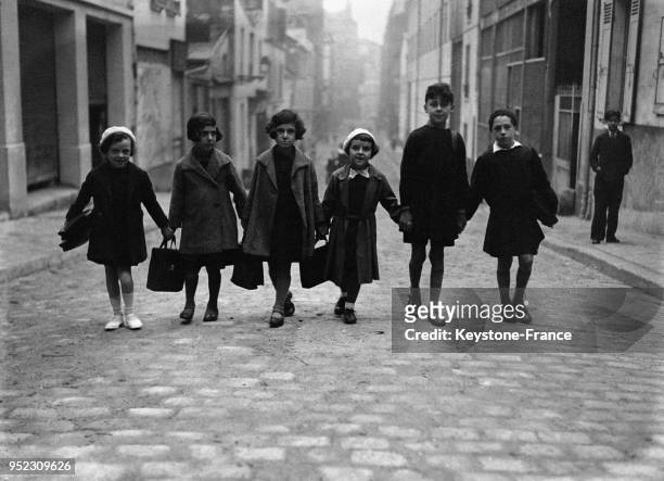 Un groupe d'enfants se rendant à l'école, à Paris, France le 2 octobre 1933.