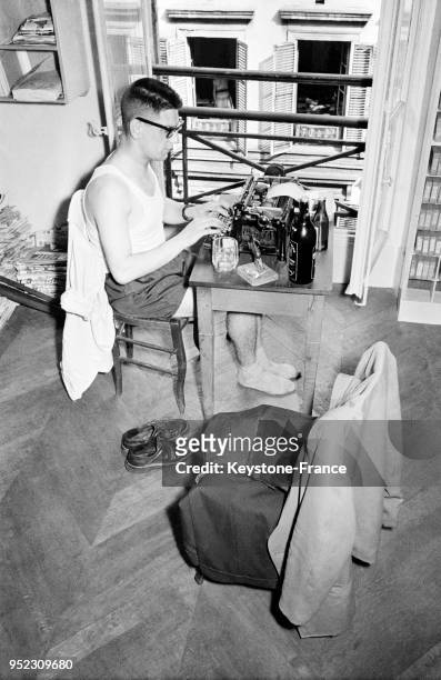 Chaleur dans un bureau d'une agence photographique parisienne, un homme travaille en short et tricot, à Paris, France en 1954.
