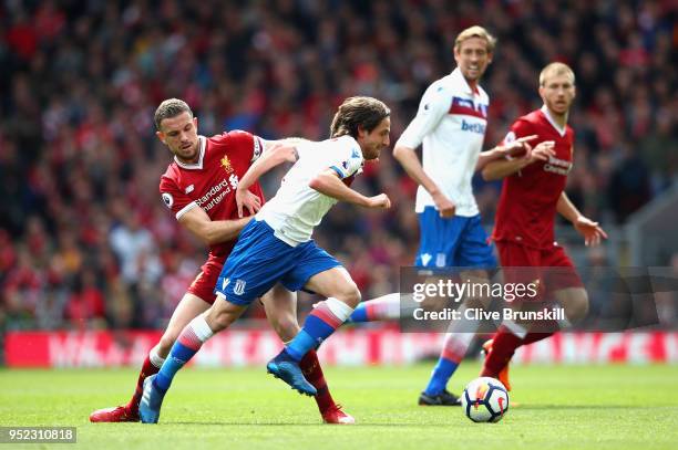 Joe Allen of Stoke City goes past Jordan Henderson of Liverpool during the Premier League match between Liverpool and Stoke City at Anfield on April...