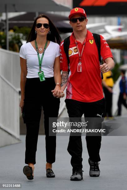 Ferrari's Finnish driver Kimi Raikkonen and his wife Minttu Virtanen walk prior to the third free practice session ahead of the Formula One...