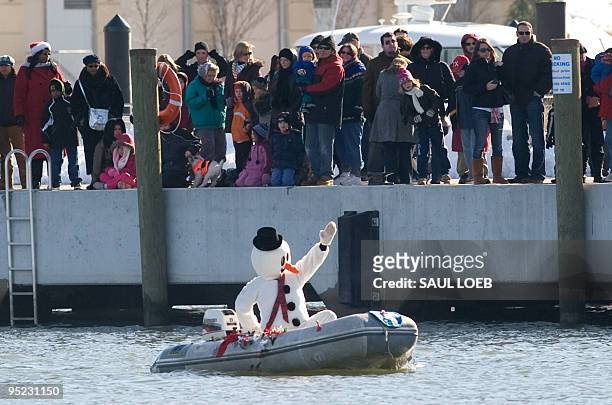 Frosty the Snowman drives an inflatable dinghy during a performance highlighted by a water skiing Santa Claus on the Potomac River at National Harbor...