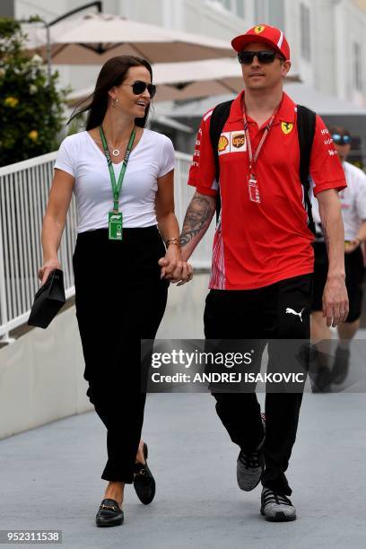 Ferrari's Finnish driver Kimi Raikkonen and his wife Minttu Virtanen walk prior to the third free practice session ahead of the Formula One...