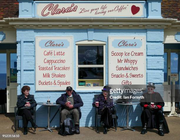 Couple dressed in gothic clothing sit outside a cafe as they attend Whitby Gothic Weekend on April 28, 2018 in Whitby, England. The Whitby Goth...