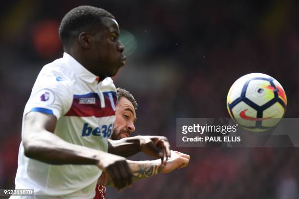 Stoke City's French defender Kurt Zouma vies with Liverpool's English striker Danny Ings during the English Premier League football match between...
