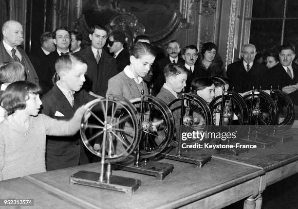 Enfants faisant tourner la roue pour le tirage de 'la Dette', à Paris, France en 1933.