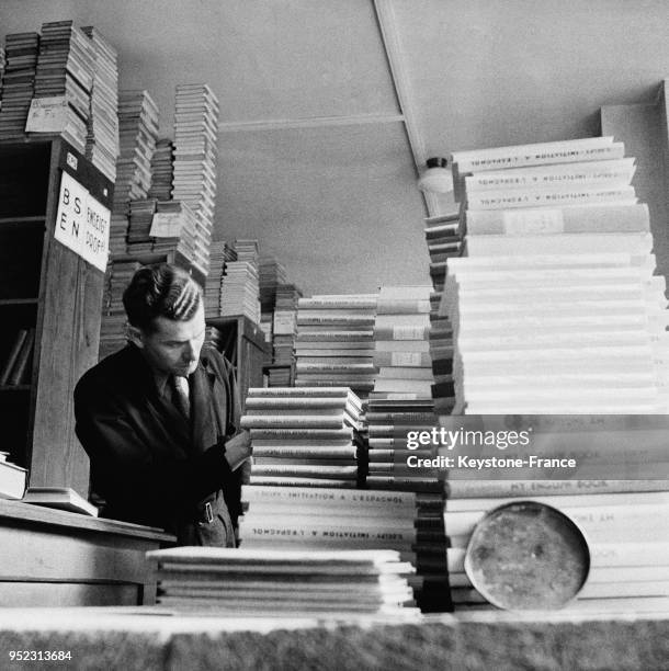 Dans un magasin, un vendeur classe les manuels scolaires, à Paris, France en septembre 1946.