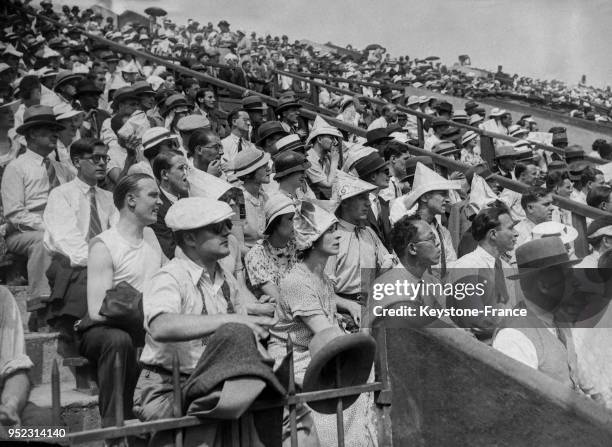 Des spectateurs qui, pour se protéger du soleil, se sont fabriqués des bicornes en papier, à Paris, France en juin 1934.