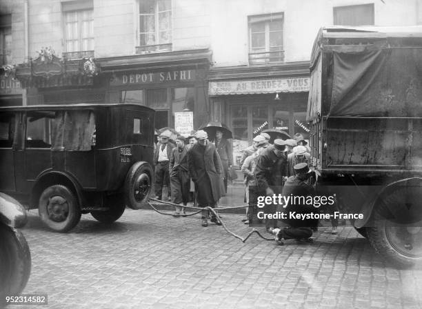 Les agents dégagent les camions après la collision boulevard Diderot, à Paris, France le 9 mars 1934.