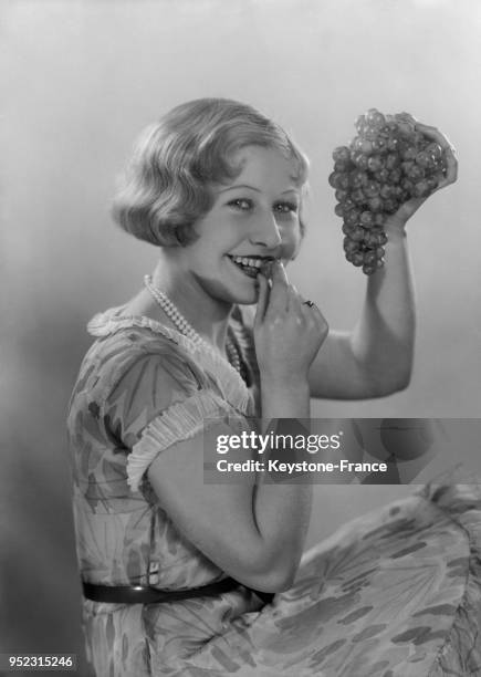 Mannequin avec une grappe de raisin dans la main à Paris, France, circa 1928.