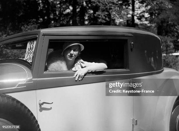 Femme au volant d'une voiture au Bois de Boulogne à Paris, France en juin 1936.