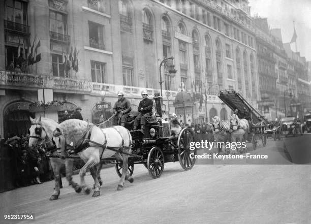 Défilé d'anciens camions de pompier du siècle précédent sur les grands boulevards à Paris, France en décembre 1932.