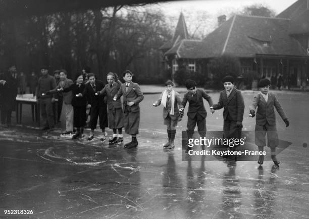 Jeunes gens patinant à la patinoire du Bois de Boulogne, à Paris, France en 1934.