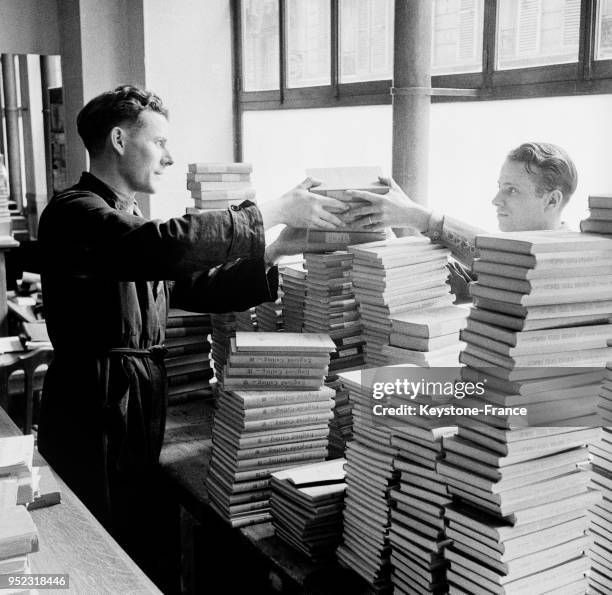 Dans un magasin, les vendeurs classent et rangent les manuels scolaires, à Paris, France en septembre 1946.