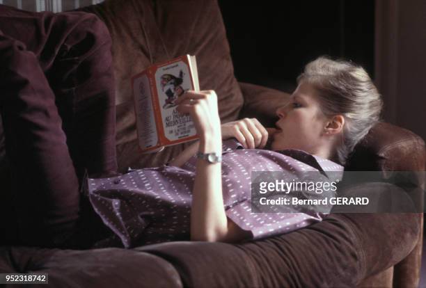 Une jeune femme lit le roman de Lewis Carrol 'Alice au Pays des Merveilles'.