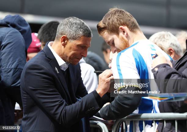 Chris Hughton, Manager of Brighton and Hove Albion signs autrographs as he arrives at the stadium prior to the Premier League match between Burnley...