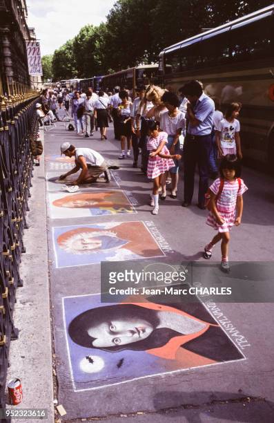 Dessins à la craie sur le trottoir devant le palais du Louvre, à Paris, en août 1988, France.