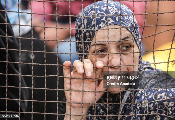 Palestinians wait in line for passport transactions to cross to Egypt following the opening of Rafah border gate in Khan Yunis, Gaza on April 28,...