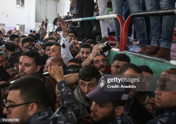 Palestinians wait in line for passport transactions to cross to Egypt following the opening of Rafah border gate in Khan Yunis, Gaza on April 28,...