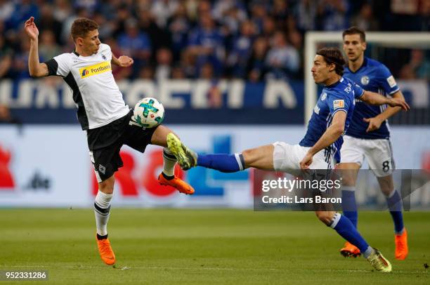 Thorgan Hazard of Moenchengladbach is challenged by Benjamin Stambouli of Schalke during the Bundesliga match between FC Schalke 04 and Borussia...