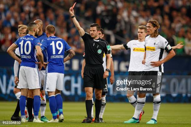 Referee Harm Osmars shows Nabil Bentaleb of Schalke the red card during the Bundesliga match between FC Schalke 04 and Borussia Moenchengladbach at...