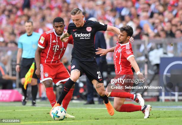 Franck Evina and Juan Bernat of Bayern Muenchen compete with Marius Wolf of Frankfurt for the ball during the Bundesliga match between FC Bayern...