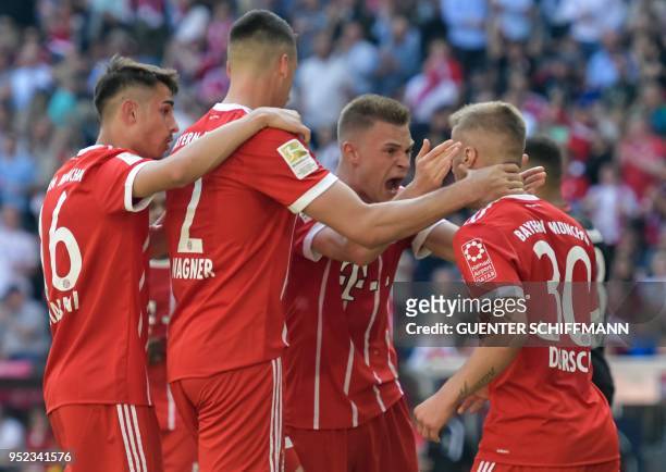 Bayern Munich's German midfielder Niklas Dorsch is congratulated by teammates after scoring the 1-0 during the German first division Bundesliga...