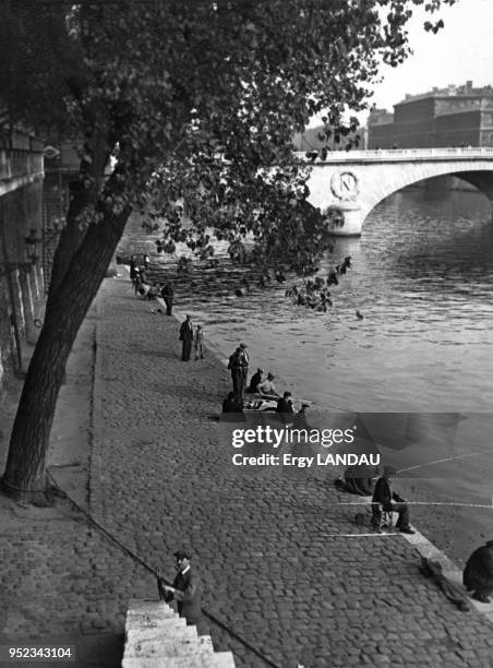 Pêcheurs au bord de la Seine, devant le pont Saint-Michel, à Paris, France.