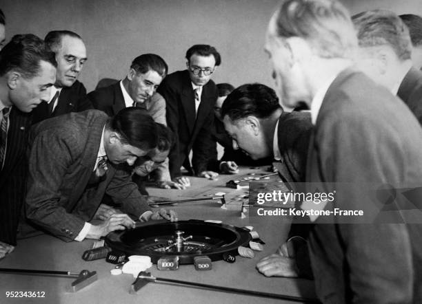 Vérification de l'équilibre d'une roulette de jeu à l'aide du niveau d'eau dans une école de formation des croupiers à Paris, France.