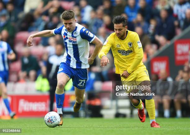 Ryan Colclough of Wigan Athletic is chased by Harry Forrester of AFC Wimbledon during the Sky Bet League One match between Wigan Athletic and A.F.C....