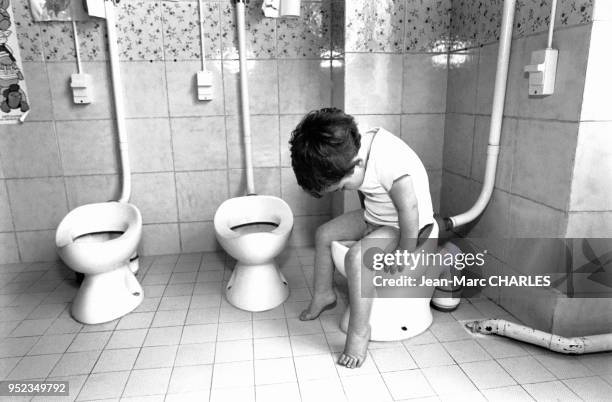 Enfant sur les toilettes dans la crèche du Mail à Paris, France.