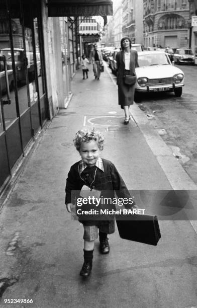 Enfant sur le chemin de l'école, le jour de la rentrée des classe, à Paris, France.