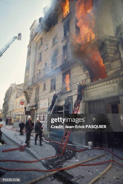Pompier intervenant sur un immeuble en feu à Paris, France.
