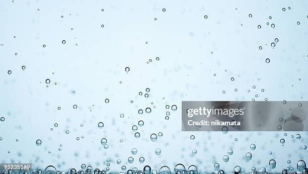 small bubbles of oxygen on blurred blue background - liquid oxygen - o2 stockfoto's en -beelden