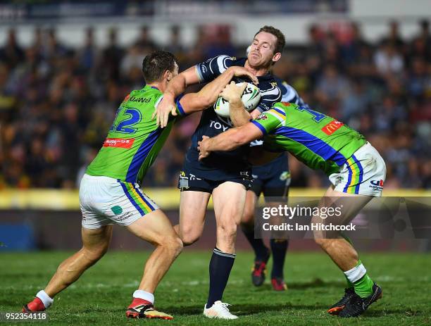 Michael Morgan of the Cowboys is tackled by Elliott Whitehead and Luke Bateman of the Raiders during the round eight NRL match between the North...