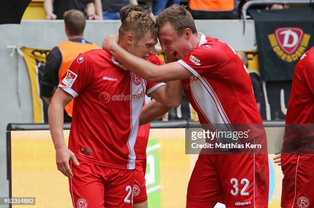 Rouwen Hennings of Duesseldorf jubilates with team mate Robin Bormuth after scoring the third goal and moving up into the Bundesliga during the...