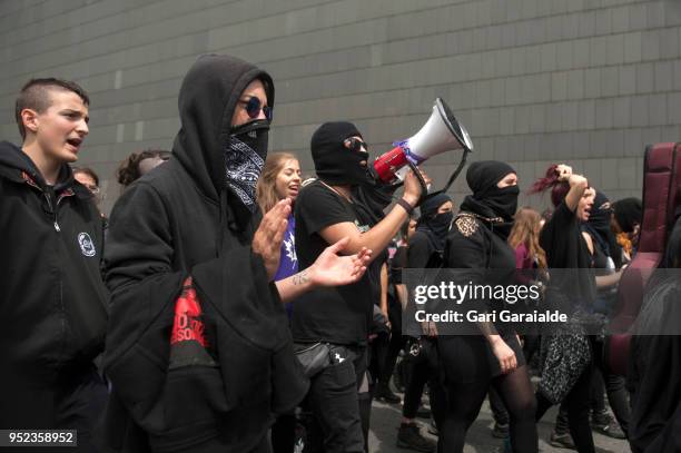 Masked people shout slogans during a demonstration against the verdict of the 'La Manada' gang case on April 27, 2018 in Pamplona, Spain. The High...