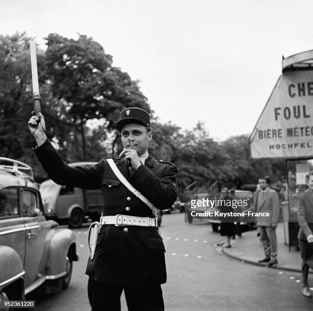 Agent de police faisant la circulation dans les rues de Paris, France en juillet 1954.