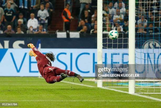 Moenchengladbach's Swiss goalkeeper Yann Sommer attempts to save a penalty shot by Schalke's Italian midfielder Daniel Caligiuri during the German...