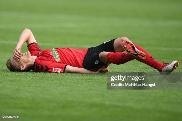 Nils Petersen of Freiburg lies on the pitch in pain during the Bundesliga match between Sport-Club Freiburg and 1. FC Koeln at Schwarzwald-Stadion on...