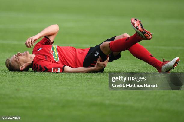 Nils Petersen of Freiburg lies on the pitch in pain during the Bundesliga match between Sport-Club Freiburg and 1. FC Koeln at Schwarzwald-Stadion on...