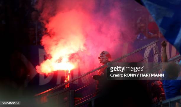 Supporters of Hamburg light flares during the German first division Bundesliga football match VfL Wolfsburg vs Hamburger SV in Wolfsburg, northern...