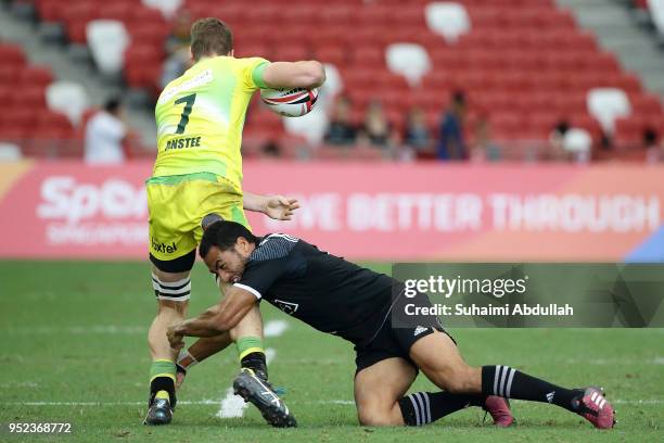 Sione Molia of New Zealand tackles Tim Anstee of Australia during the 2018 Singapore Sevens Pool D match between New Zealand and Australia at...